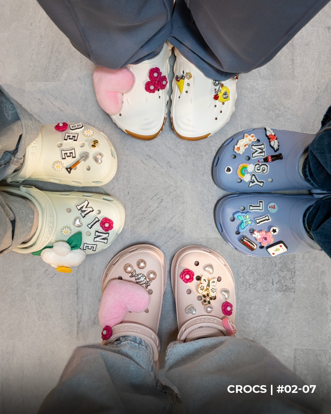 A colorful array of Valentine's Day themed Jibbitz charms decorating Crocs clogs.