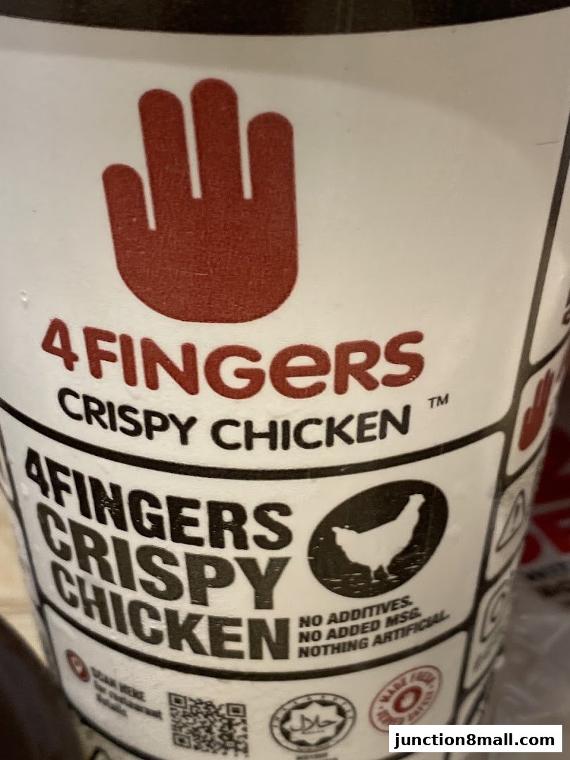 A close-up of a cup with the '4 Fingers Crispy Chicken' logo and branding.