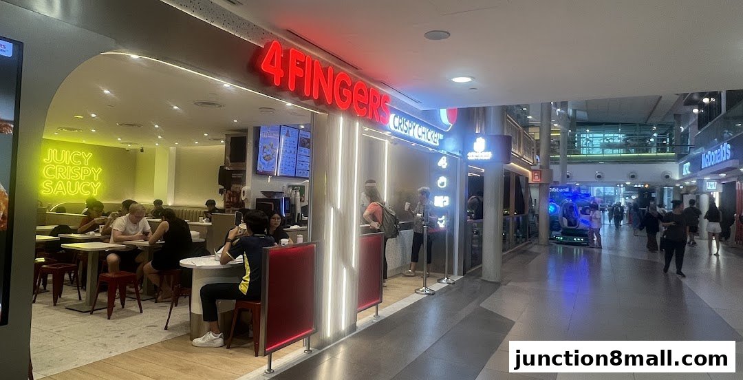 The exterior of a 4 Fingers Crispy Chicken restaurant with customers dining inside.