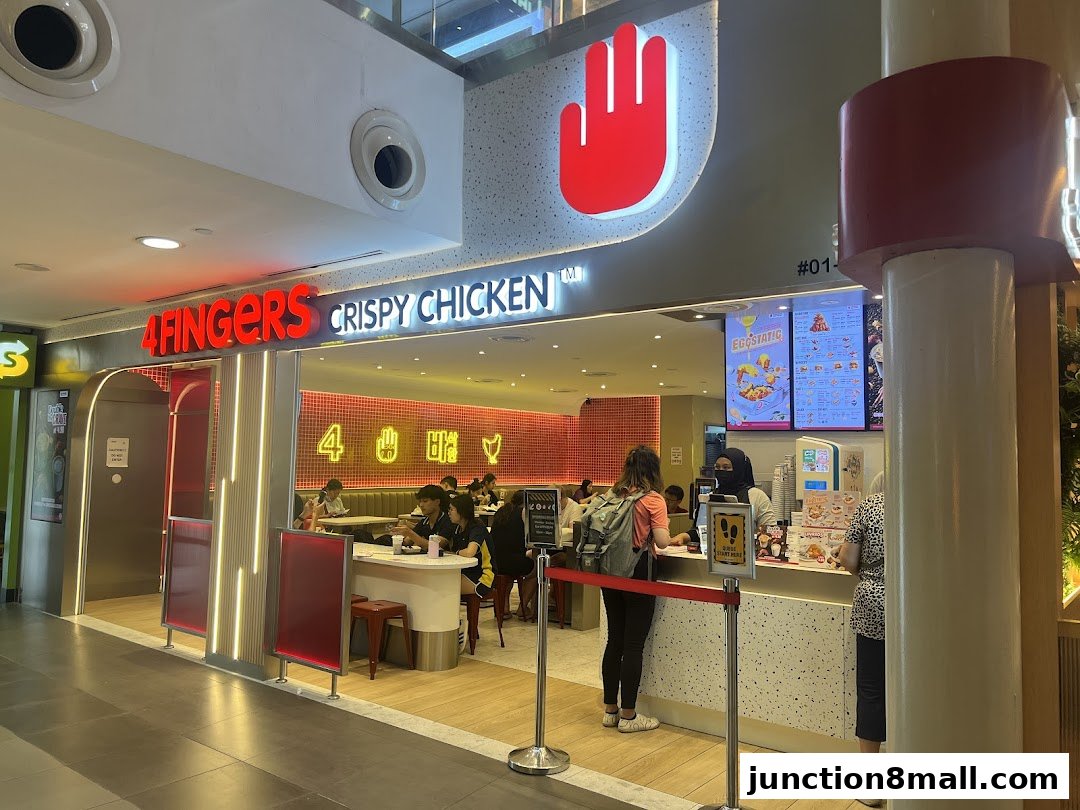 The exterior of a 4 Fingers Crispy Chicken restaurant with customers ordering at the counter.
