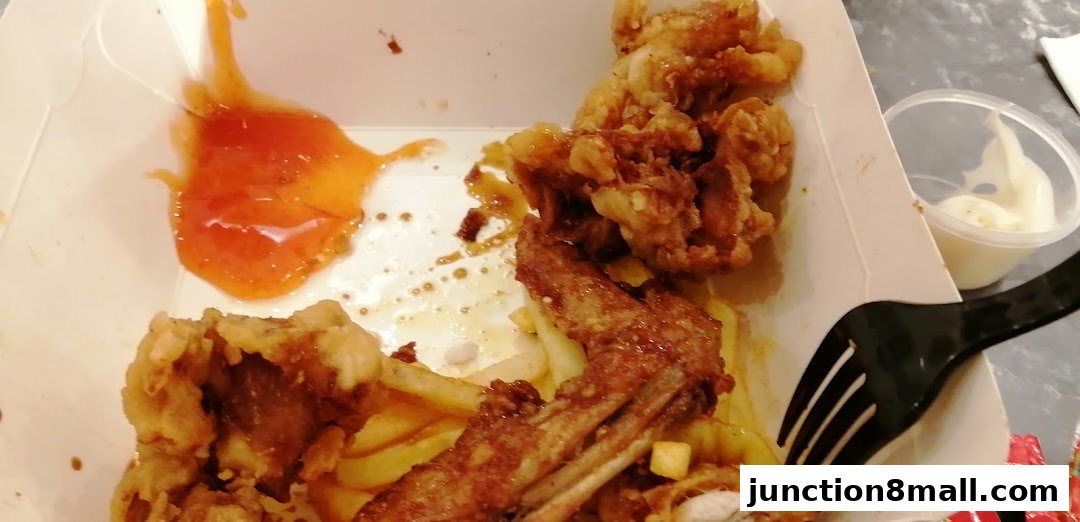 A close-up of crispy fried chicken pieces with fries, sauce, and a side of dip.