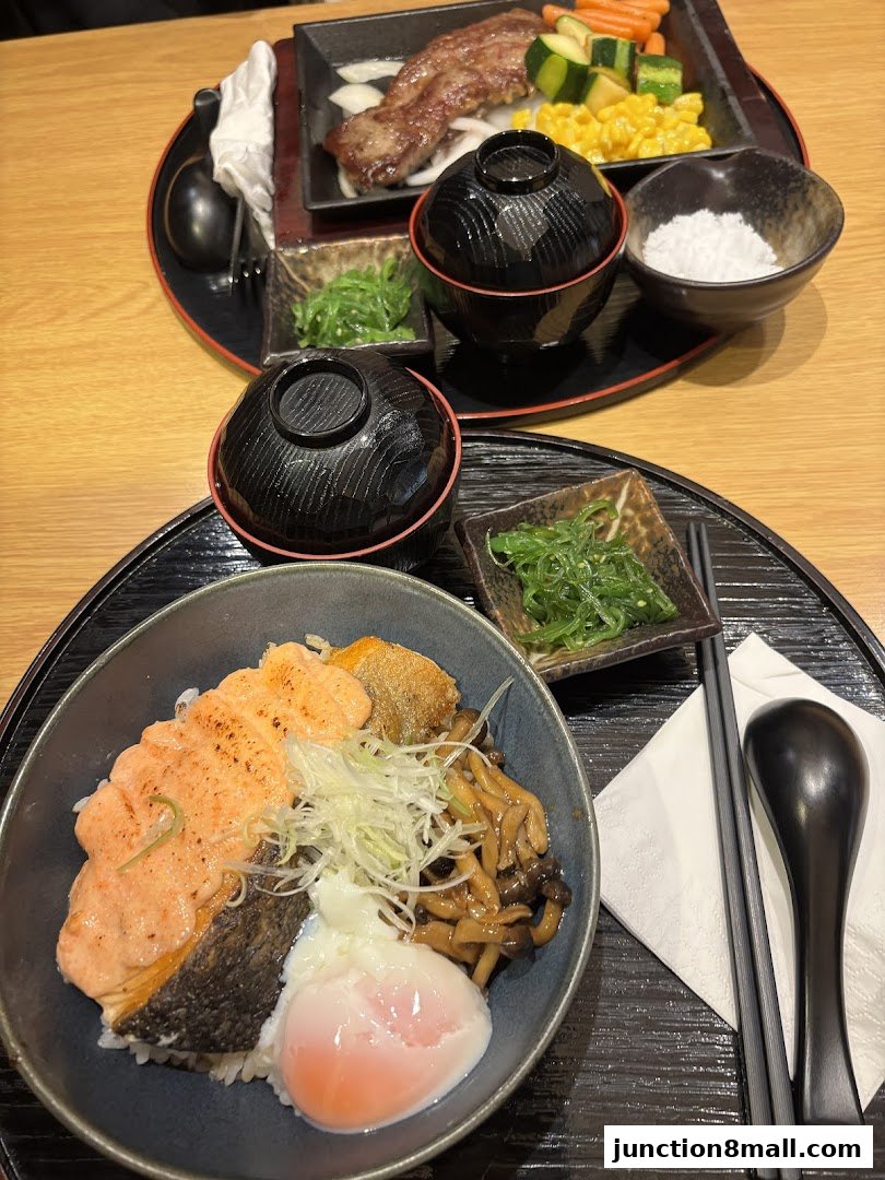 A close-up of two Japanese meals, one with grilled salmon and a poached egg, the other with steak and vegetables.