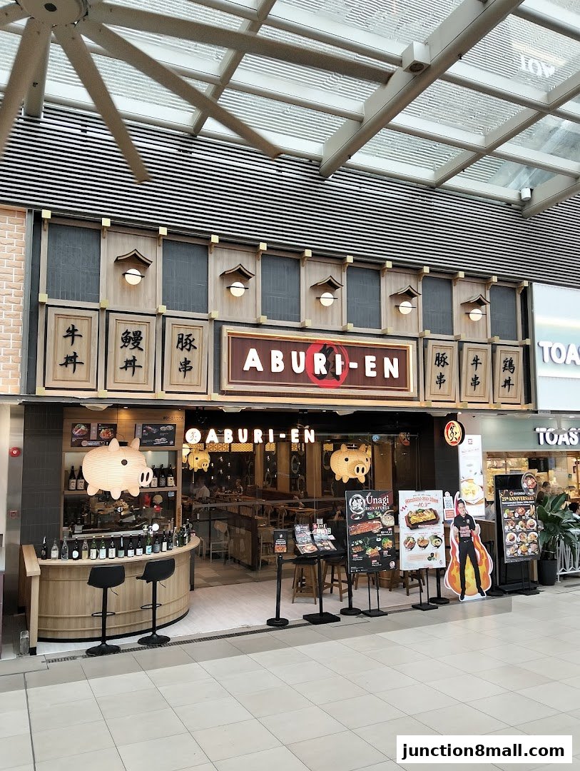 The exterior of the Aburi-EN restaurant with a prominent sign and decorative pig lanterns.