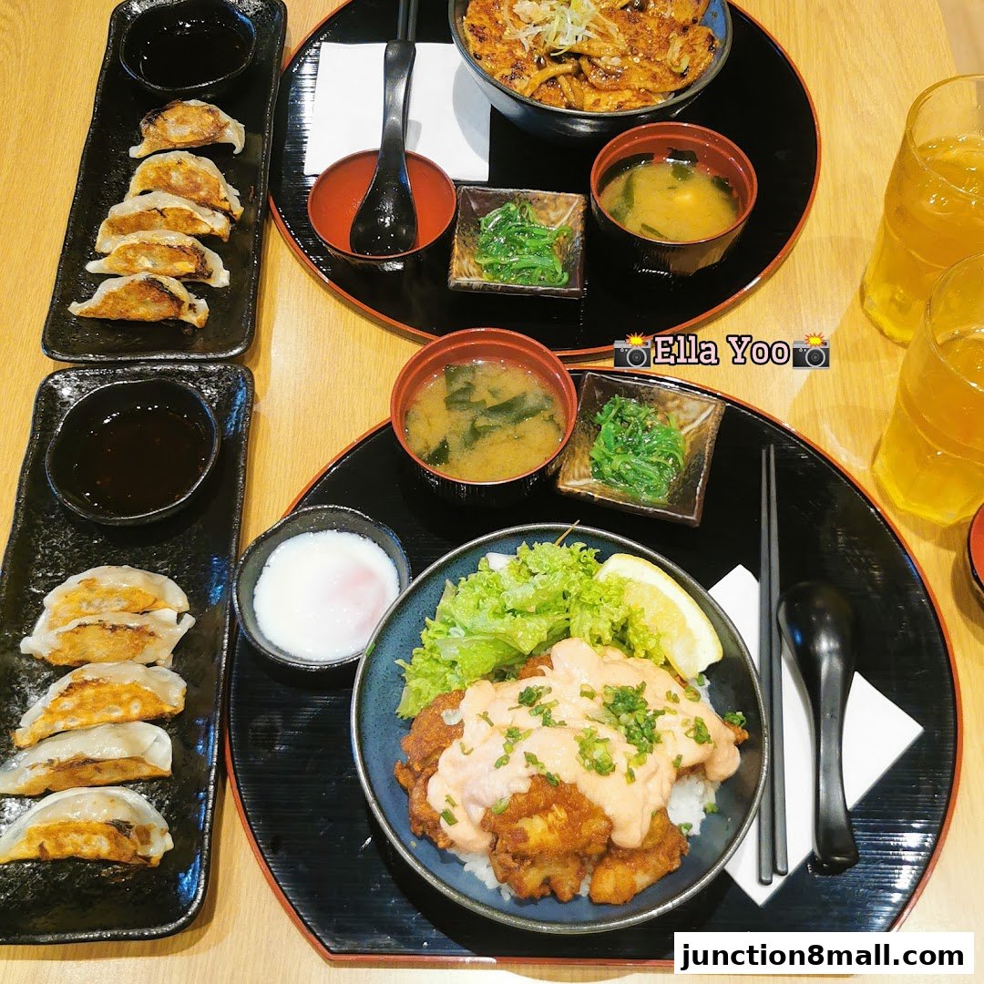 A delicious Japanese meal featuring gyozas, rice bowls, miso soup, and drinks.