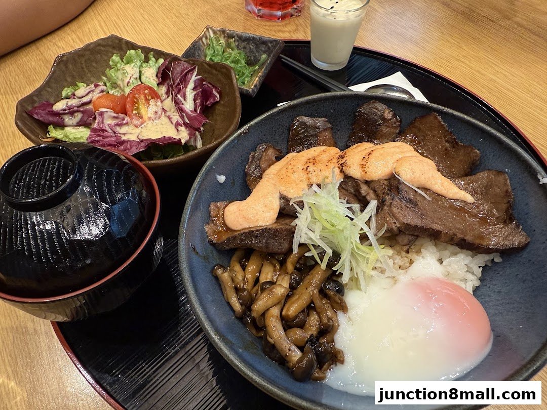 A delicious Japanese meal featuring grilled beef, rice, mushrooms, a soft-boiled egg, and a side salad.