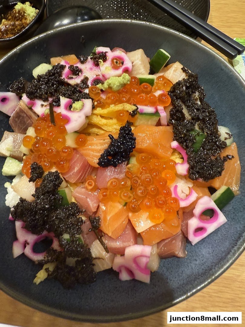 A close-up of a colorful Chirashi bowl filled with fresh sashimi, ikura, and black caviar.