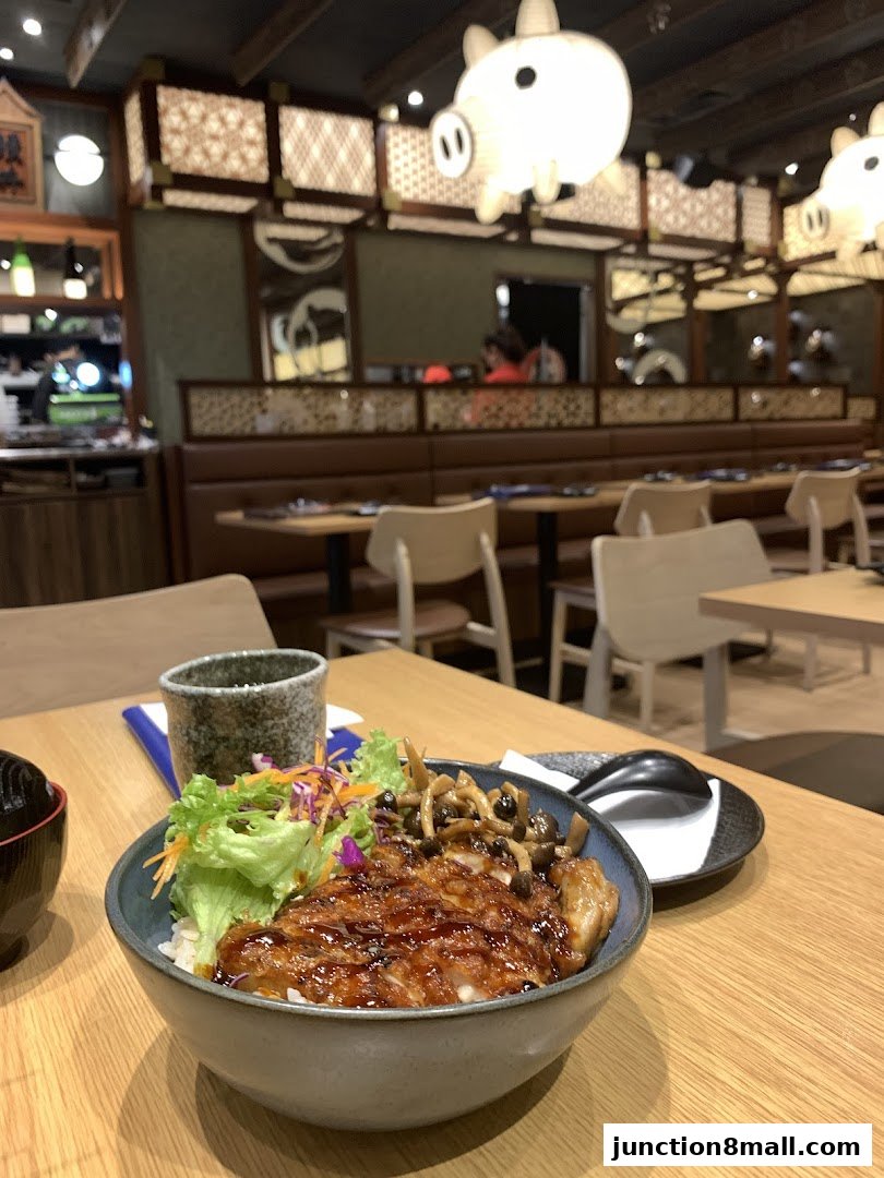 A delicious bowl of teriyaki chicken with rice and salad, served in a Japanese restaurant.
