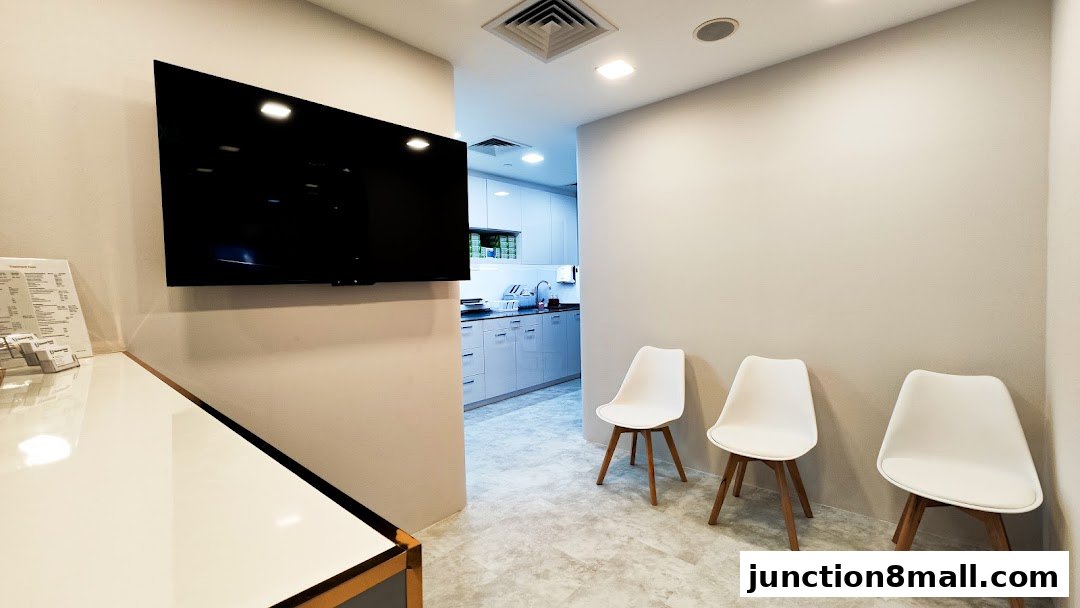 A clean and modern dental clinic waiting area with white chairs and a TV.