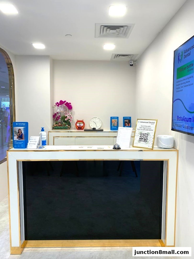 The reception counter of Advanced Dental Bishan, featuring promotional materials and a QR code.