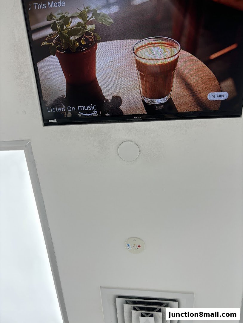 A television screen displays a coffee drink and a potted plant, with a 'Shop' button visible.