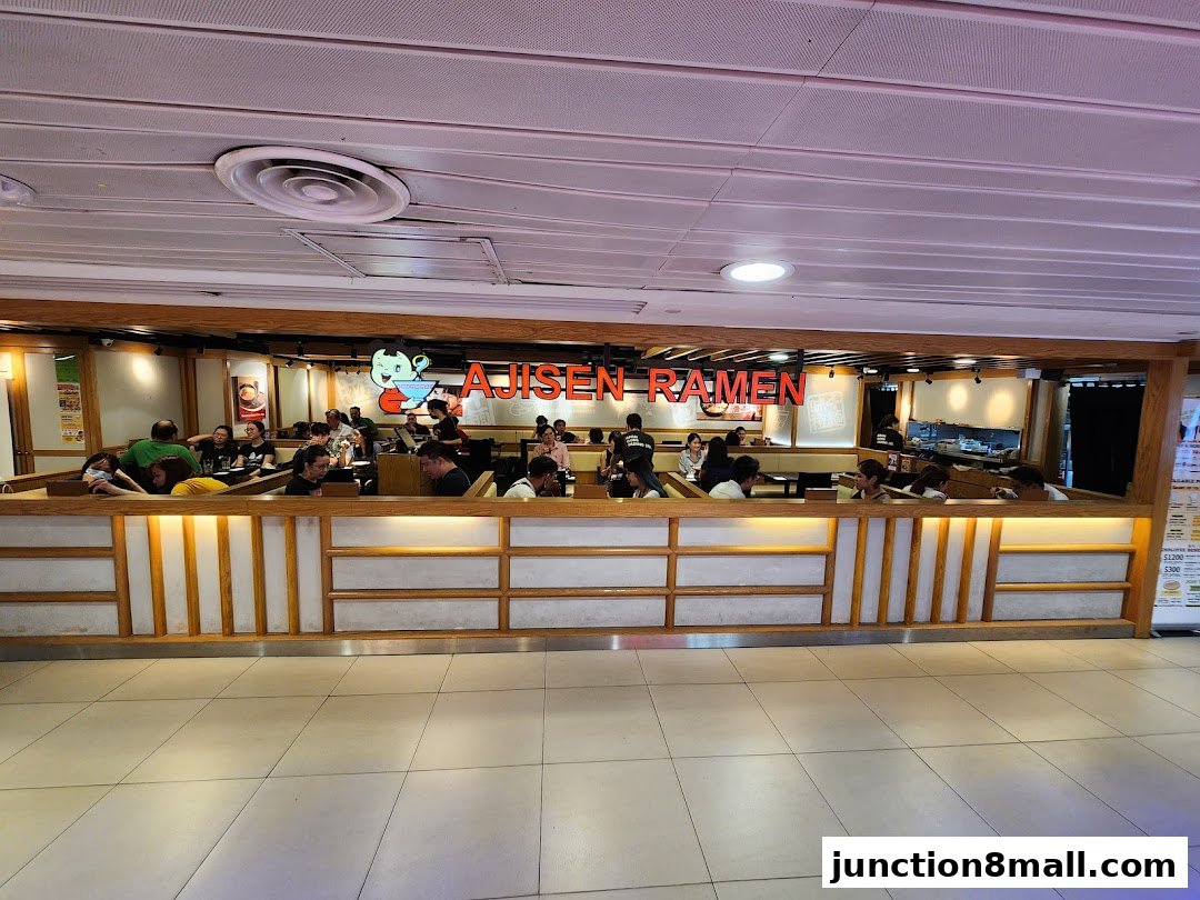 Interior view of Ajisen Ramen restaurant with customers seated at tables.