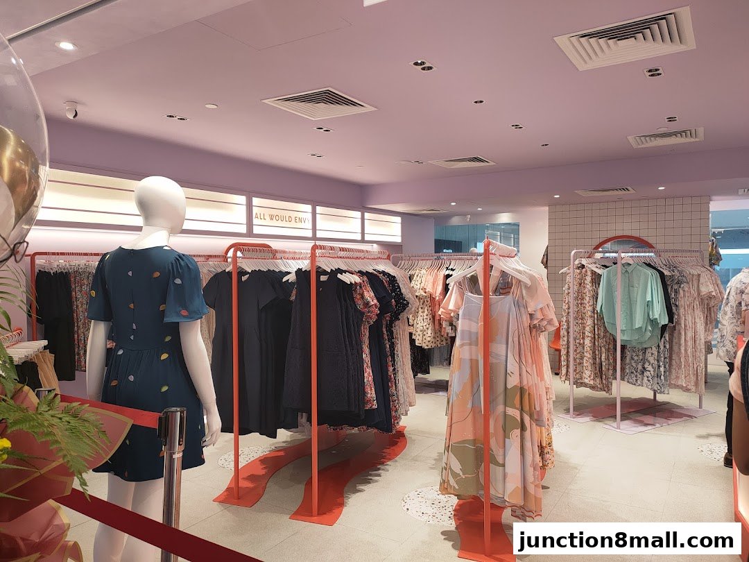 Interior view of a clothing store with mannequins and racks of dresses.