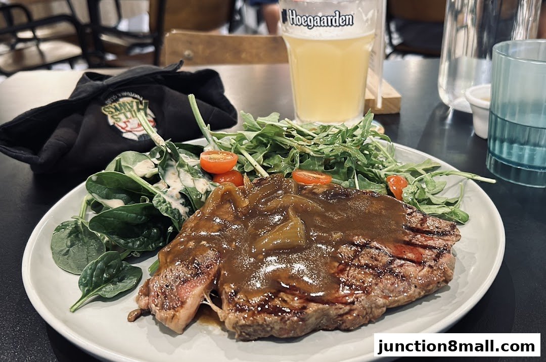 A plate of steak with salad and a glass of beer on a table.