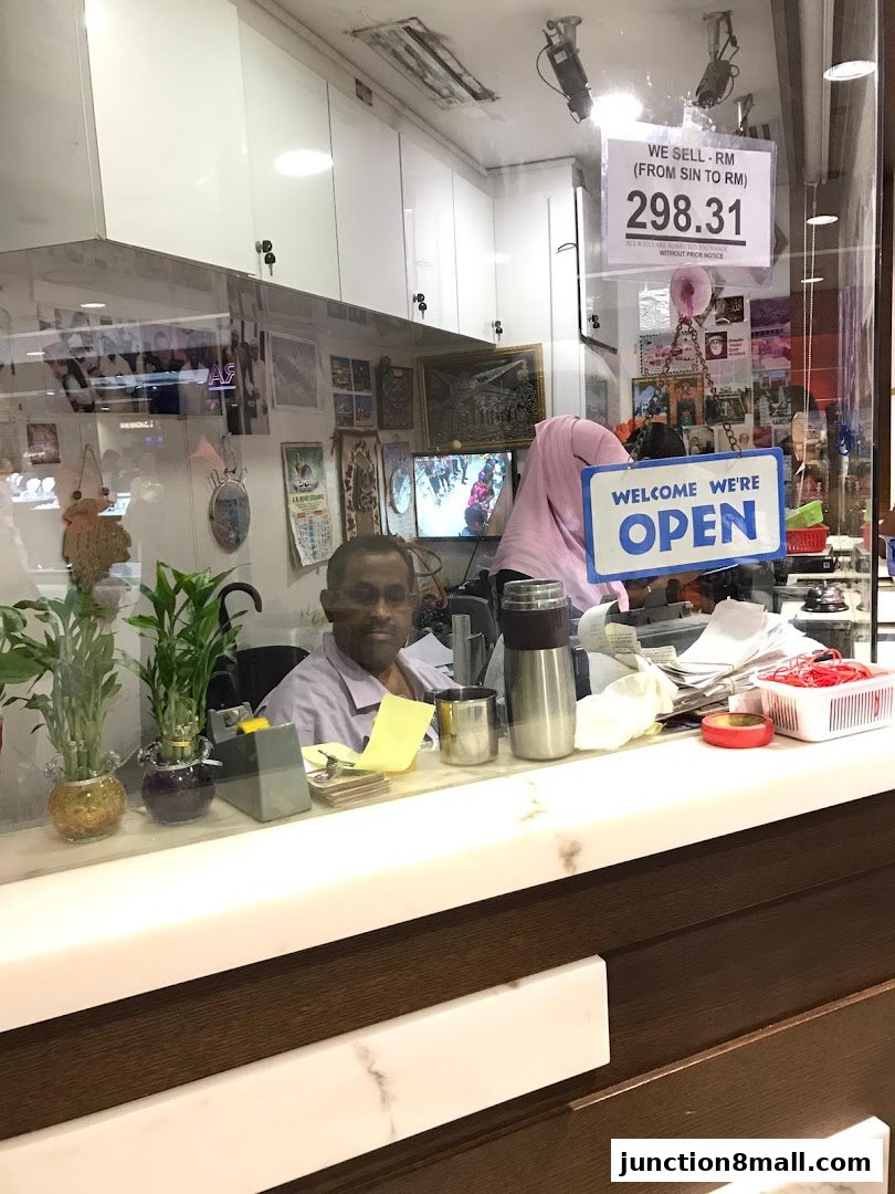 An AR Money Exchange counter with a 'Welcome We're Open' sign and current exchange rate displayed.