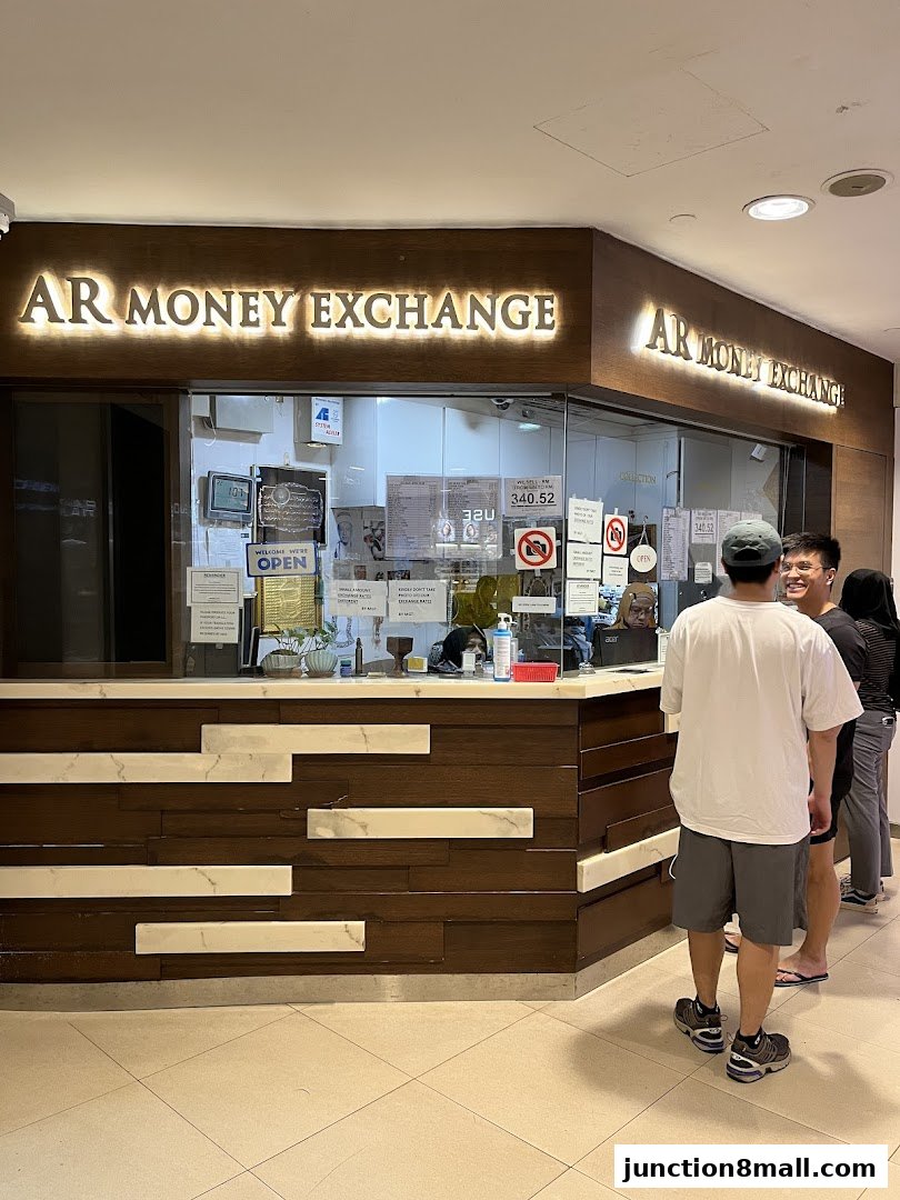 A money exchange shop with a prominent sign and customers waiting in line.