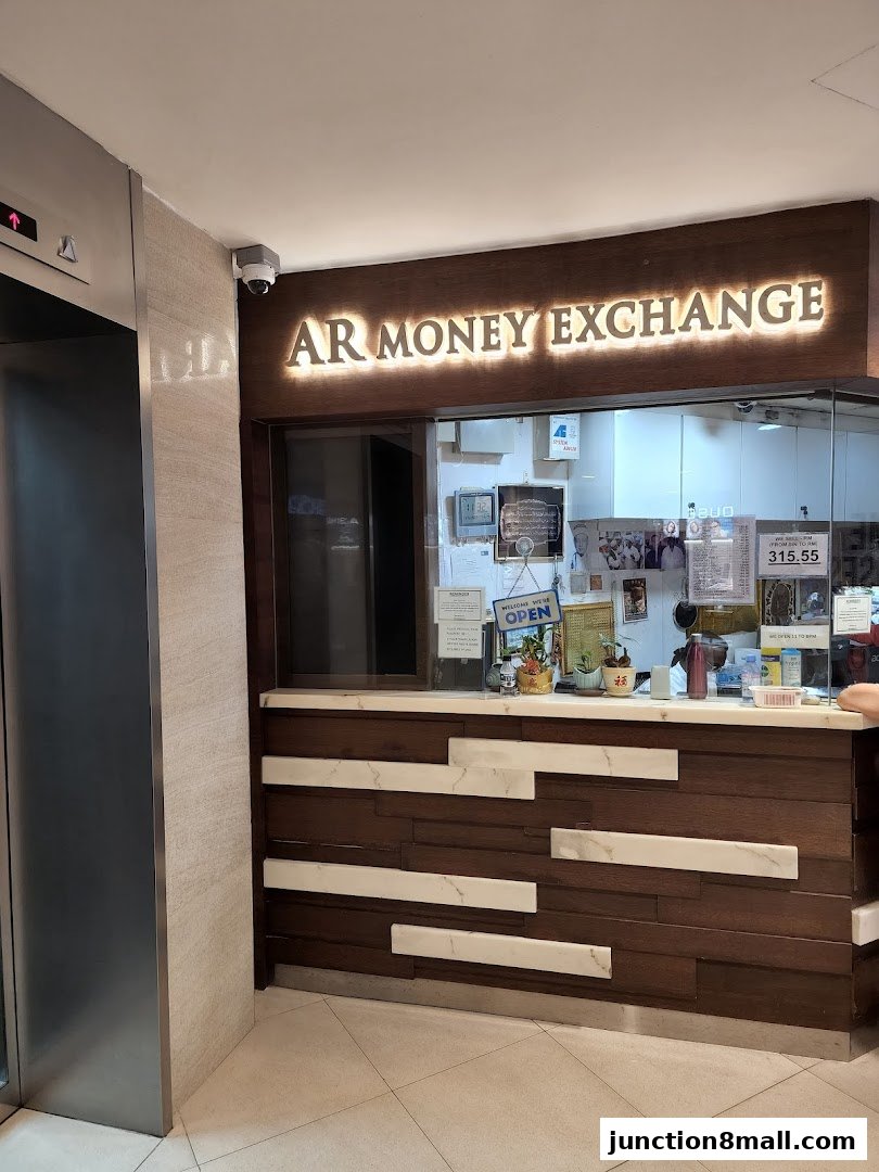 The AR Money Exchange shop front with illuminated signage and a counter.