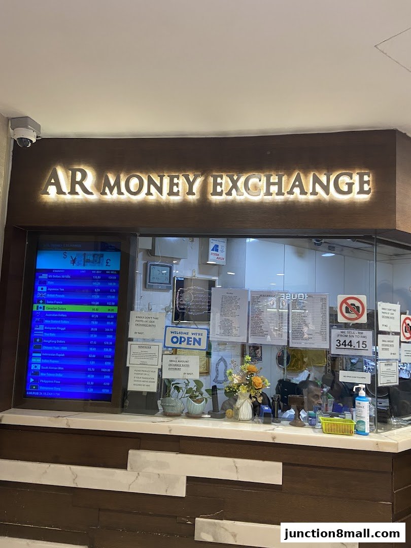 AR Money Exchange shop front with currency rates displayed on a screen and a welcome sign.