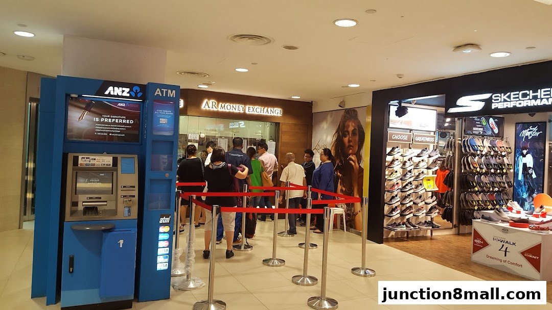 People queuing at AR Money Exchange next to an ANZ ATM and a Skechers store.