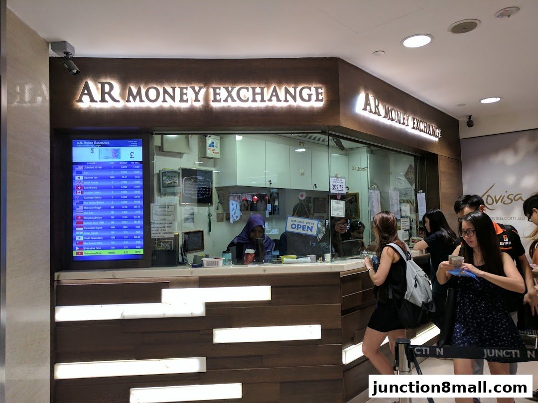 AR Money Exchange shop with customers at the counter and a digital currency exchange rate display.