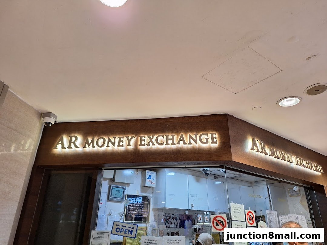 The illuminated storefront of AR Money Exchange, featuring prominent signage and a welcoming 'Open' sign.