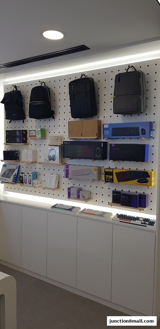 A retail display featuring backpacks, keyboards, mice, and other tech accessories.
