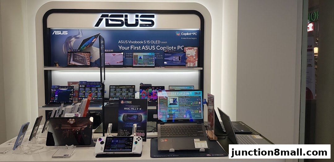 A display of ASUS laptops and a handheld gaming device in a retail store.