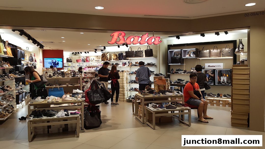 Interior view of a Bata shoe store with customers browsing footwear and handbags.