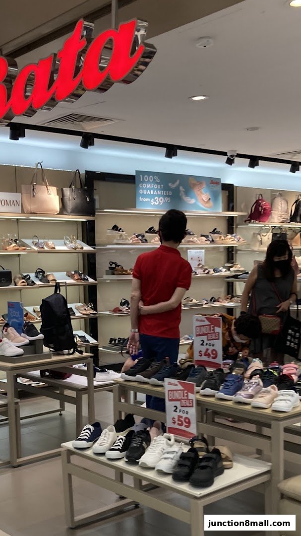 Interior of a Bata shoe store with various shoes displayed and customers browsing.