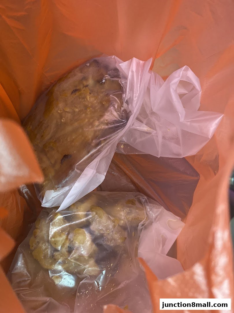 Two servings of food in plastic packaging inside an orange bag.