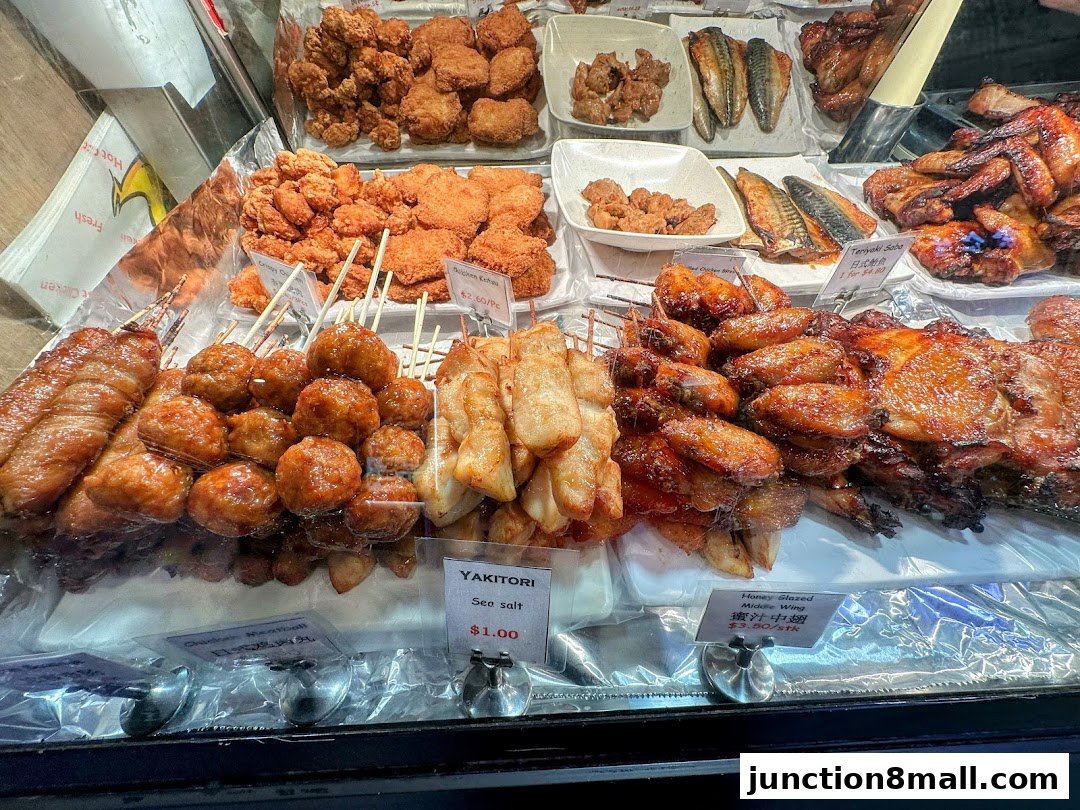 A display of various grilled and fried meats, including chicken wings, meatballs, and fish.