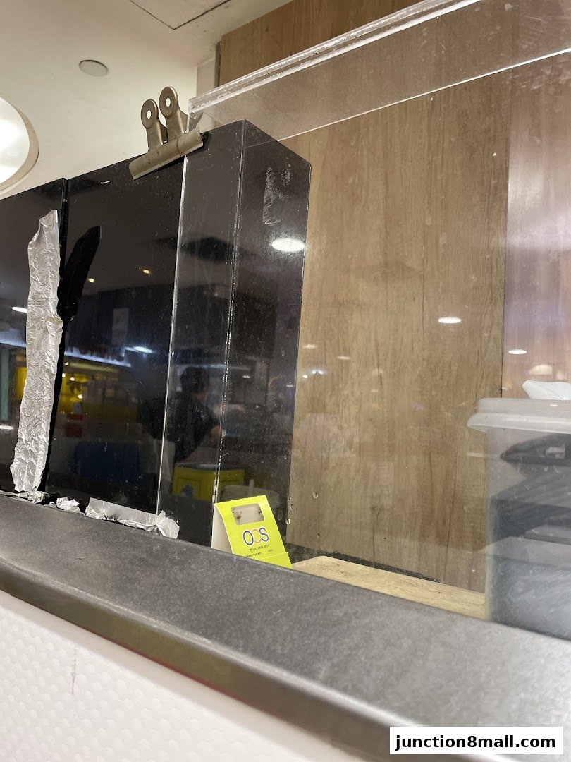 A close-up view of a counter with a black display and a small yellow sign.