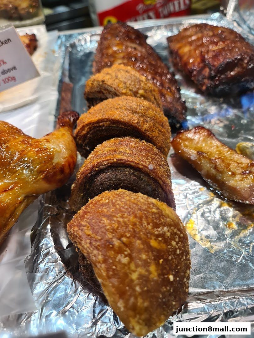 A close-up of various BBQ meats, including roasted chicken, ribs, and crispy pork belly.