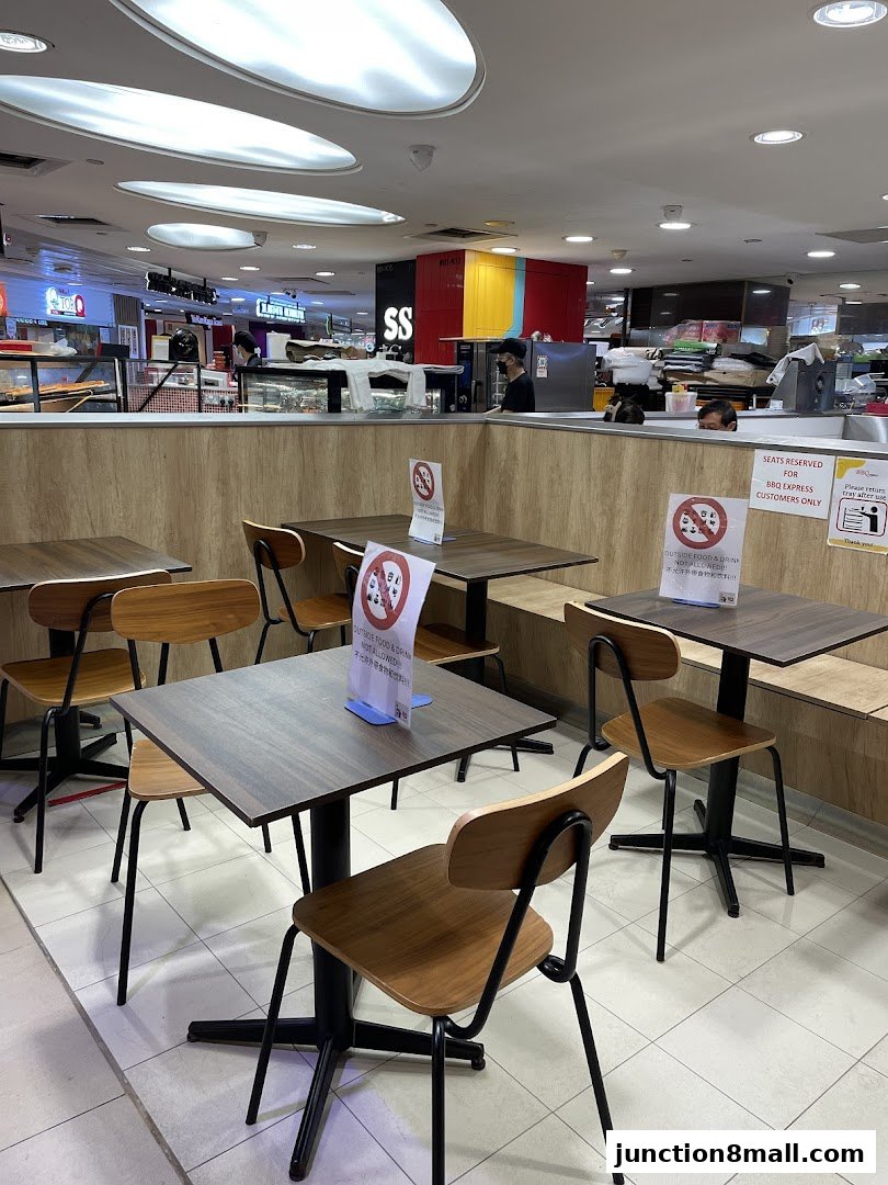 Interior view of BBQ Express with tables, chairs, and social distancing signs.