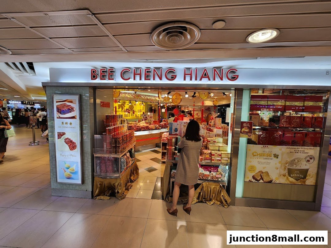 The exterior of a Bee Cheng Hiang shop, showcasing various food products and a customer.