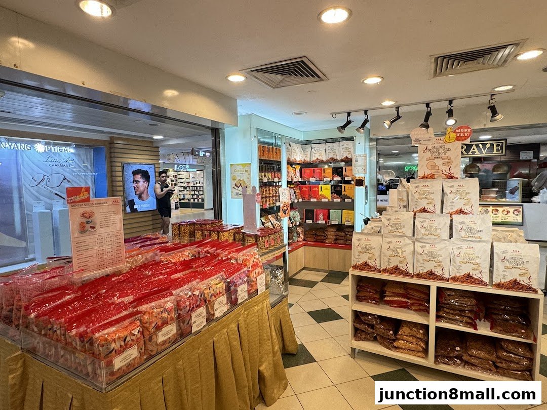 Interior view of a Bee Cheng Hiang shop showcasing various packaged snacks and a promotional display.