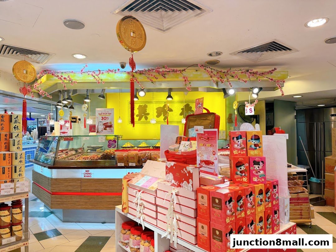 Interior of a Bee Cheng Hiang shop with festive decorations and various food products on display.