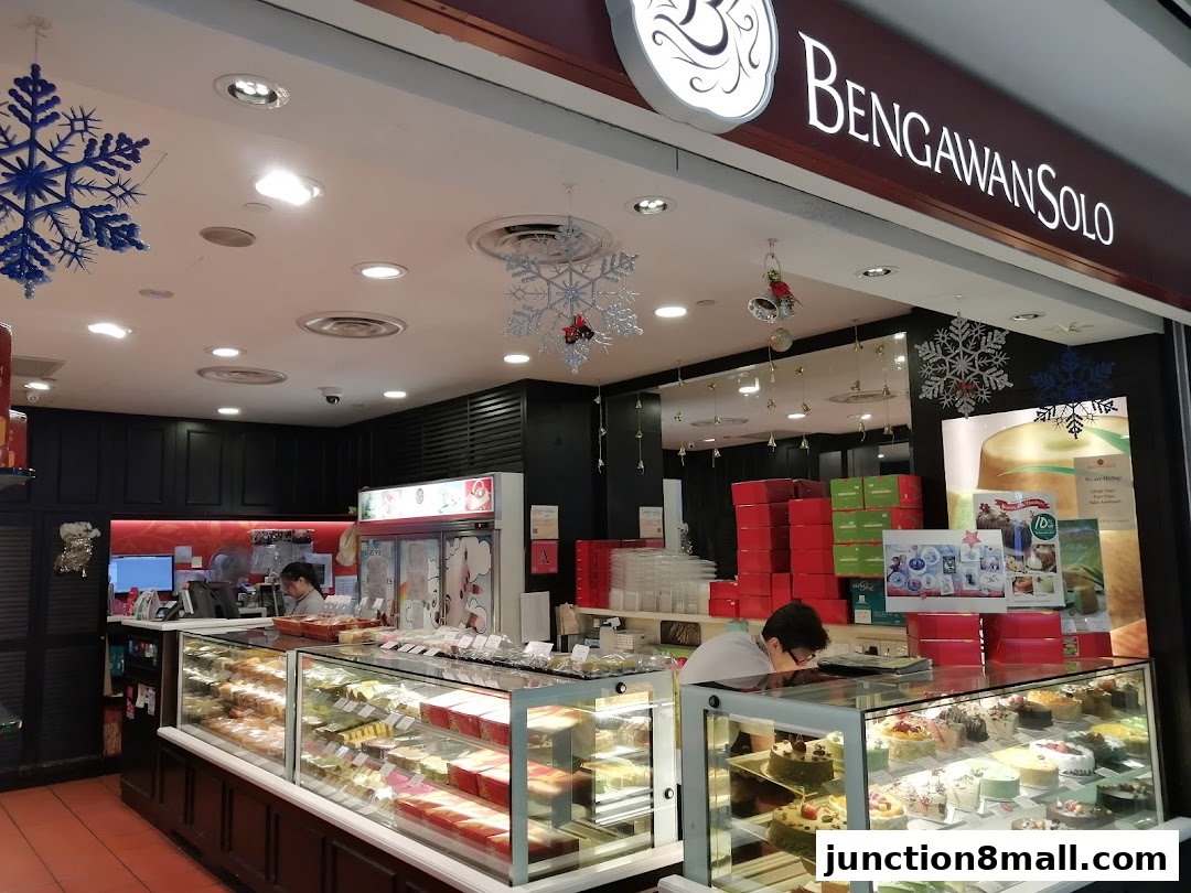A well-lit bakery shop front with display cases full of cakes and pastries.