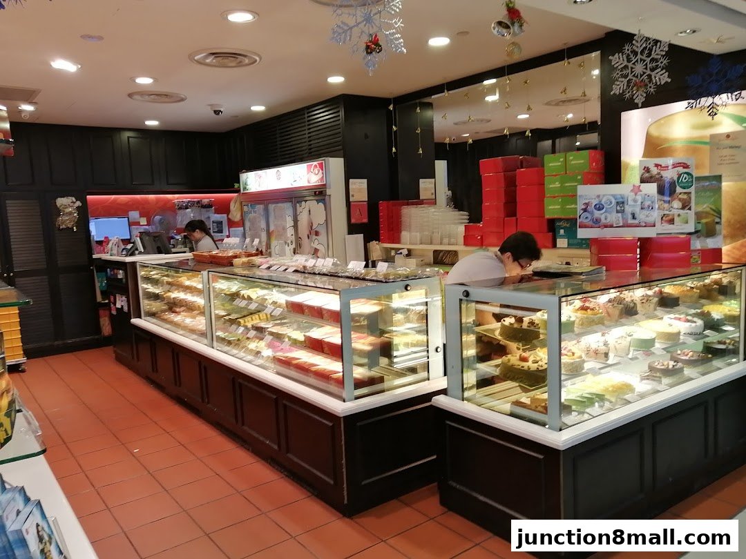 Interior view of a bakery with display cases filled with cakes and pastries.