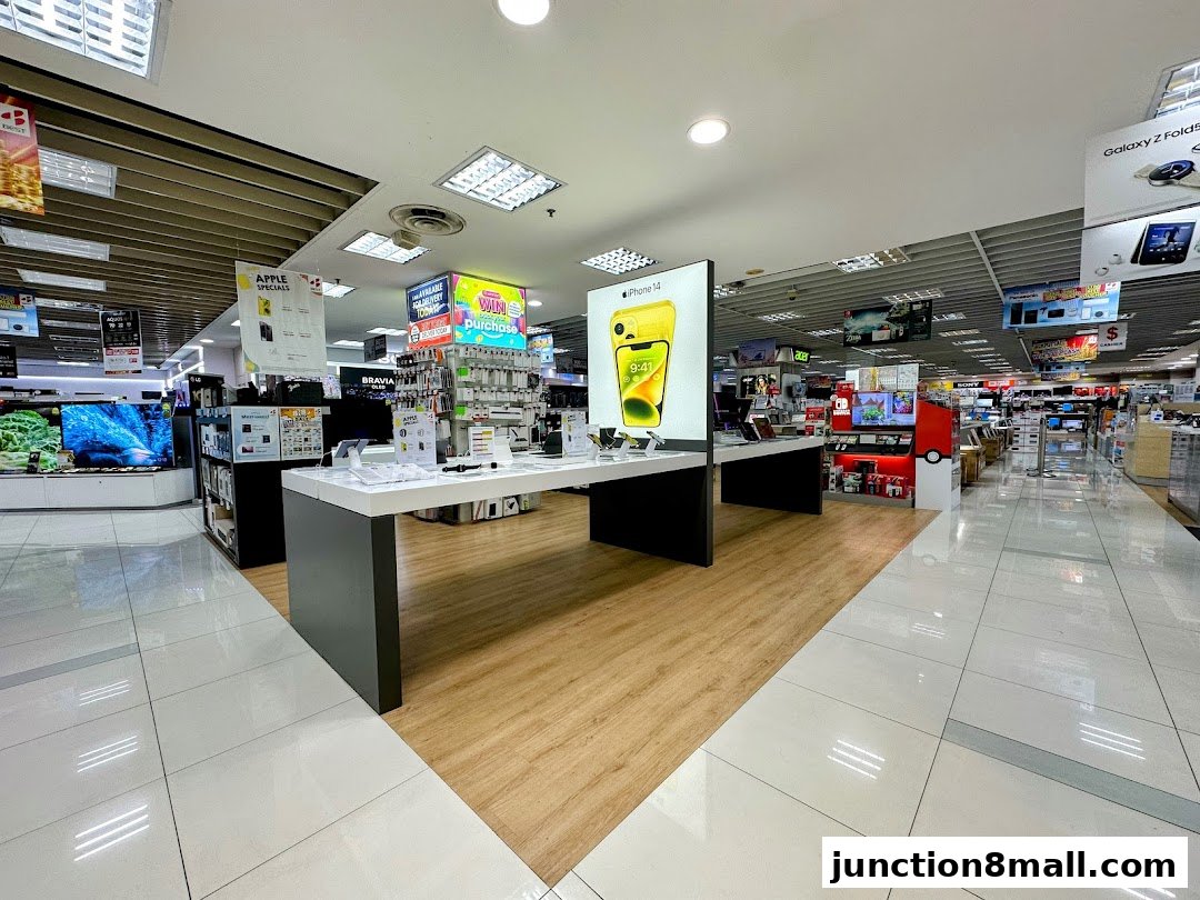 Interior view of a brightly lit electronics store showcasing various gadgets and displays.