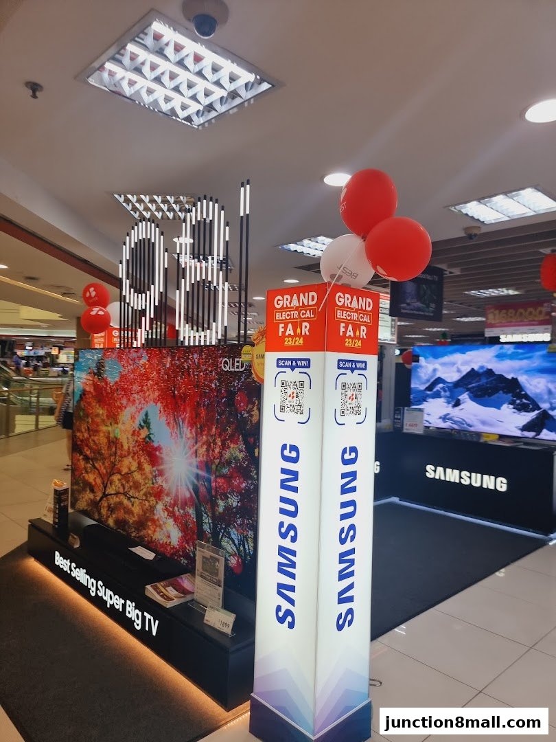 A display of Samsung QLED TVs and promotional signage with balloons.