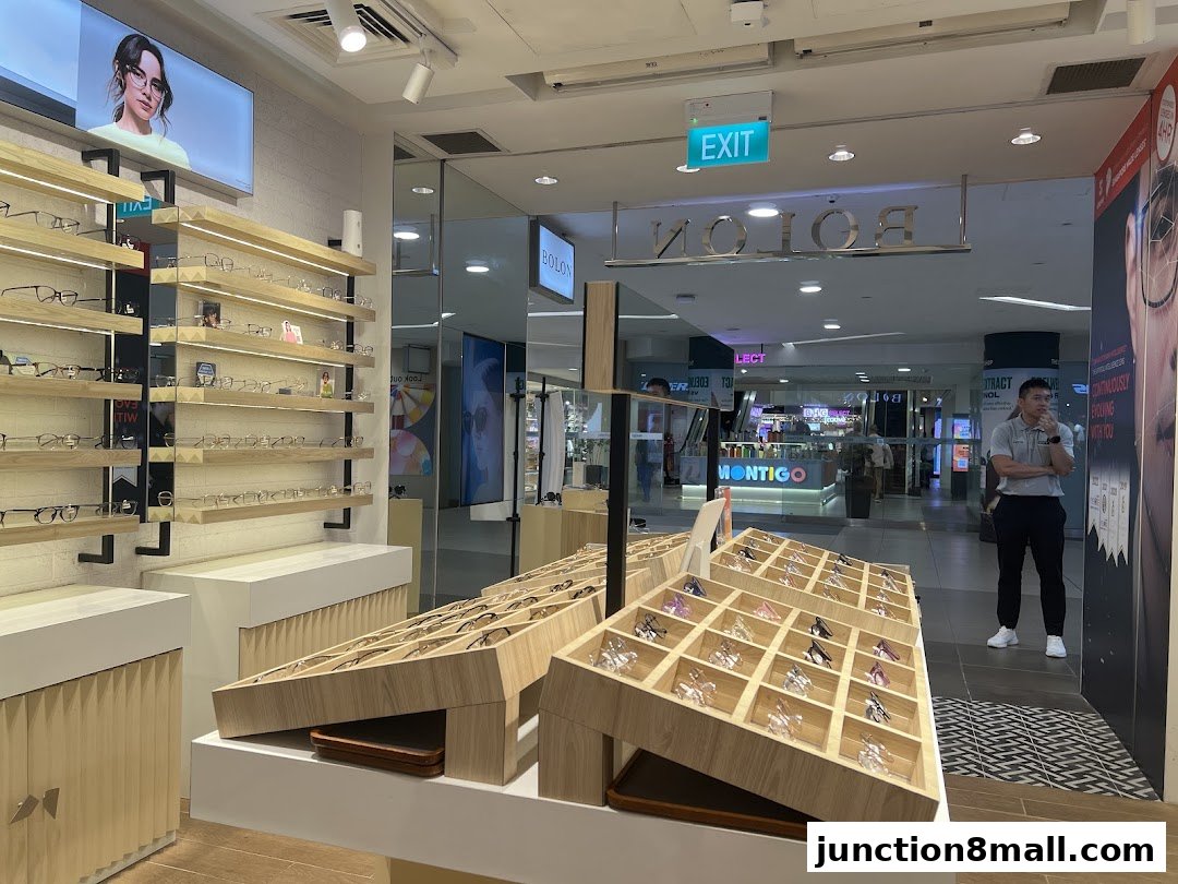 Interior of a modern eyewear shop with displays of glasses and a staff member.