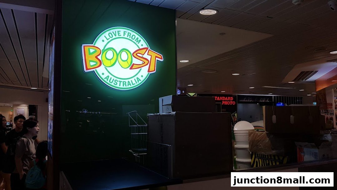 The Boost Juice shop front with its iconic logo and a few customers waiting.