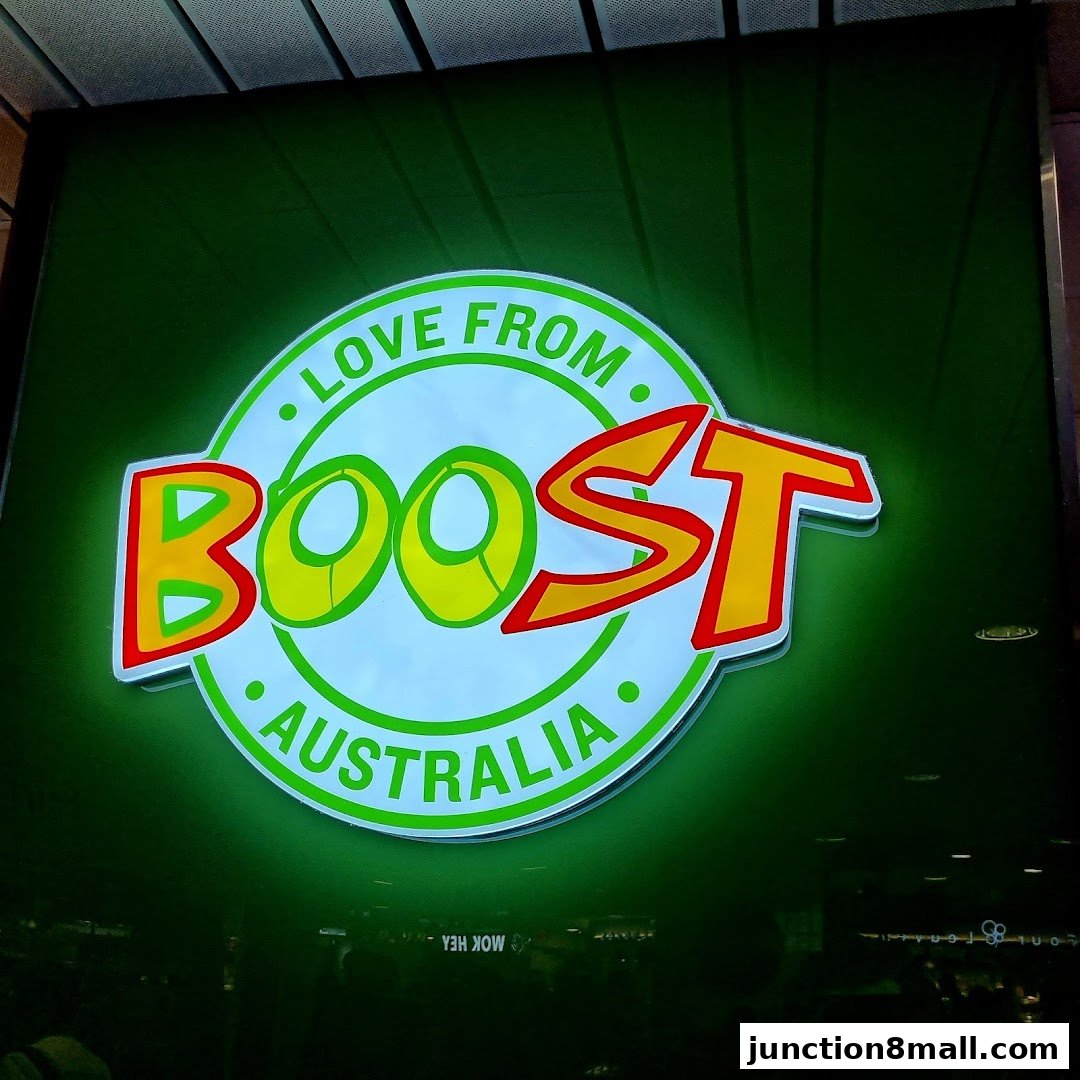 A brightly lit green sign with the Boost Juice logo, featuring the words 'Love from Boost Australia'.