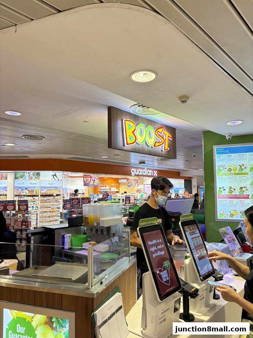 A Boost Juice counter with staff and customers ordering via touchscreens.