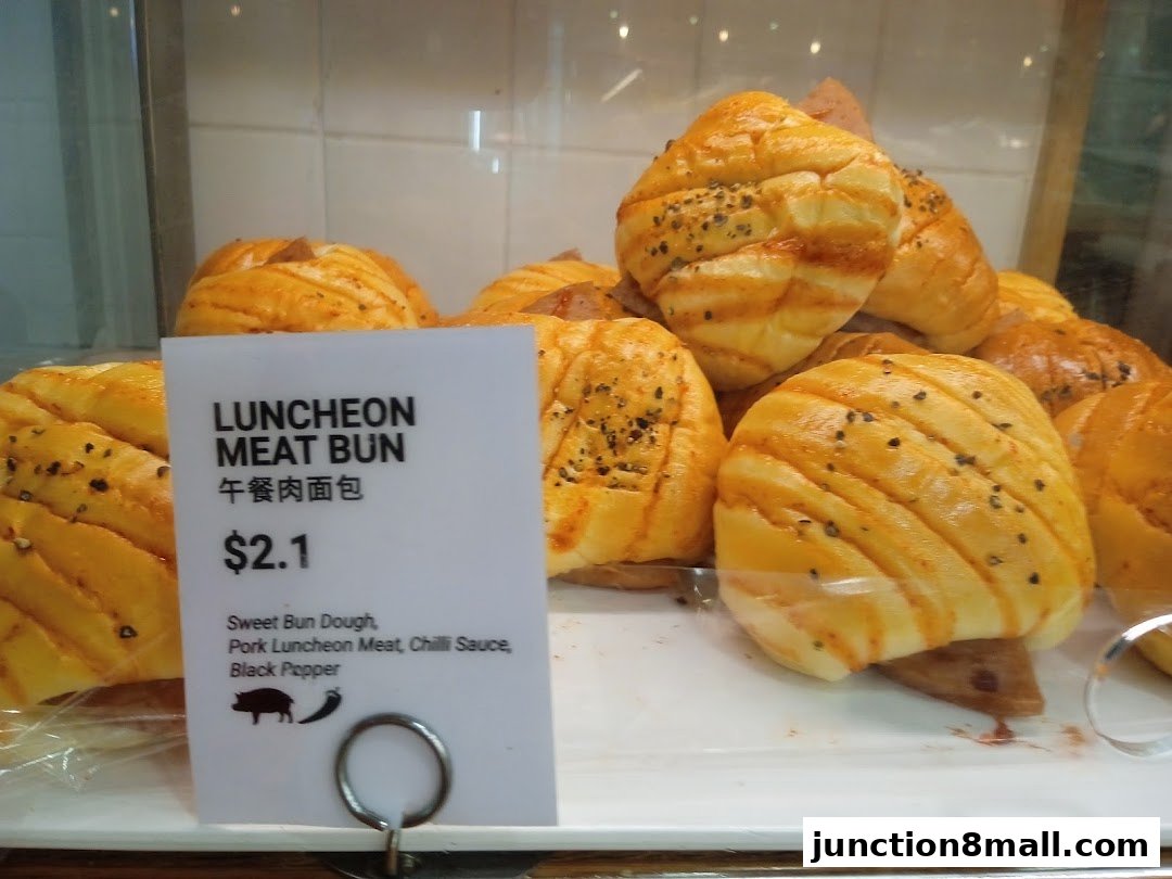 A display of freshly baked luncheon meat buns with a price tag.