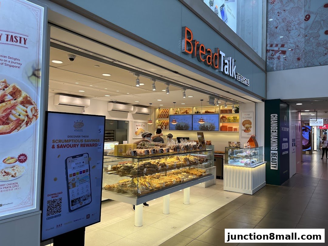 The exterior of a BreadTalk bakery with displays of fresh bread and pastries.