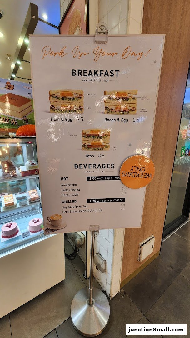 A menu board displaying breakfast sandwiches and beverages with prices.