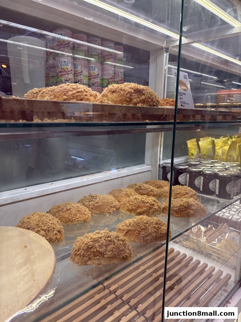 A display case filled with freshly baked bread topped with shredded meat.