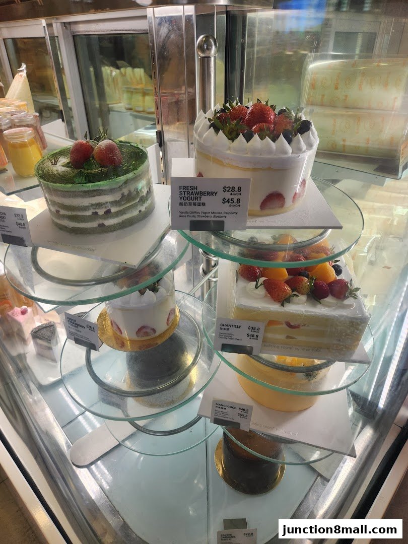 A display case filled with various beautifully decorated cakes and desserts.