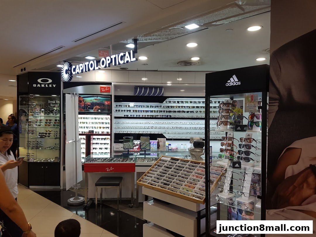 Capitol Optical shop displaying various brands of eyewear, including Oakley and Adidas.